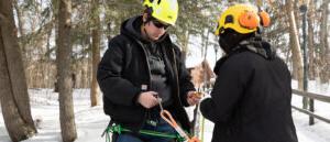 Paul Smith's professor teaching student to use climbing equipment